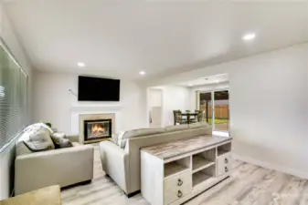 In 2022, this home was updated with luxury plank floors, trim, interior paint, recessed lighting and more! The wood burning fireplace creates a great ambiance in this light and bright living room.