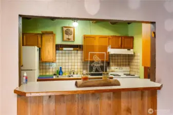 The open pass-through keeps the kitchen connected to the living areas, making gatherings easy. Handcrafted wood cabinets, tiled backsplash, and rustic accents blend with the quirky Bigfoot artwork, reminding you of the home’s unique story.