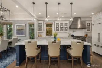 The chef's kitchen is as stunning as it is functional-gleaming with white marble countertops that crown an oversized island. Two subzeros, two sinks and three ovens makes entertaining a breeze!