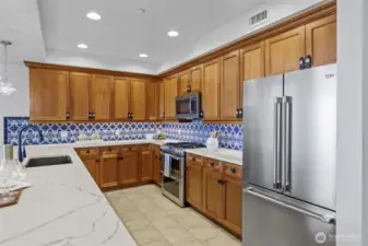 Chef’s dream kitchen featuring quartz countertops, premium stainless steel appliances, and hand-painted tile accents.