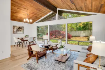 Open-Concept Living Room, Soaring ceilings and rich wood accents create a warm, Northwest feel. Floor-to-ceiling windows frame the lush, private backyard—perfect for relaxing or entertaining.