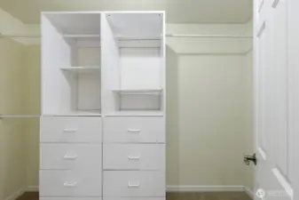 Large walk-in closet attached to primary bedroom with built-ins for storage