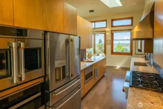 Chef's kitchen with Wolf range, two Miele dishwashers, Miele steam/convection oven with built-in water supply, Cafe french door oven, an extra large Cafe refrigerator, drawer microwave, prep sink, instant hot water, and large pantry.
