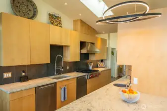 The kitchen also features granite counters and custom cabinets, and a large pantry tucked behind the left side cabinets.