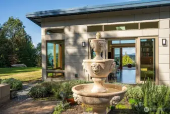 The mature, enclosed garden is thoughtfully landscaped with a fountain, raised beds, and drought-resistant perennials.