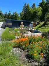 The gardens and oversized two car garage with shop and storage seen in the background.