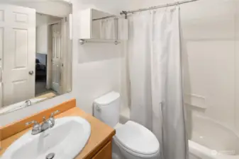 Clean and modern bathroom with a full tub/shower combo, vanity with storage, and neutral finishes.