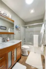 Style meets sparkle. This charming full bath features designer finishes, a marble-top vanity, and a twinkle in its eye (literally—that light fixture!).