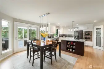Dining Area & Kitchen – Open concept layout with access to outdoor deck; island-centric kitchen.