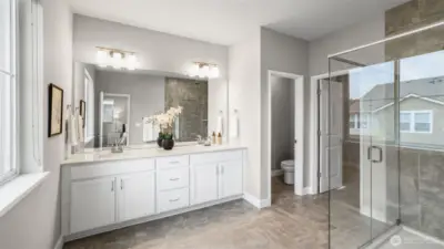 Primary bath features dual vanities and quartz counters