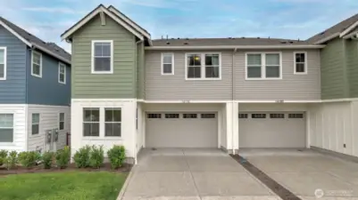 Two car garage with EV charging and driveway provides easy access to the home