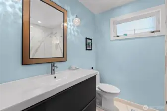 Second bathroom on the main level. It features low maintenance sinter stone walk-in shower and flooring