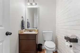 Half bath on the main level. Whitewashed shiplap wall making this room light and airy.
