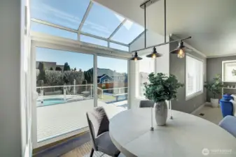 The breakfast nook features conservatory-style windows above.