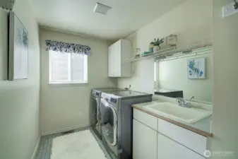 On the main floor the laundry room features overhead cabinets and a deep soaking tub.