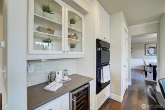 Glass front cabinets are perfect for showing off your collectables. A wine refrigerator is also featured here!