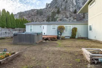 Back of home. The hot tub is working, but needs a new cover. It can also be removed.