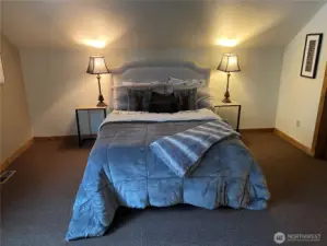 Upper level master bedroom view of primary queen bed