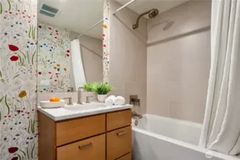 Stylish ensuite bathroom featuring warm wood cabinetry and modern finishes.