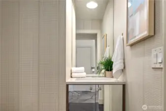 Sleek vanity and stylish wallpaper in the main level powder room.