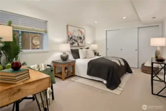 Large lower level bedroom with ample space and soft lighting.