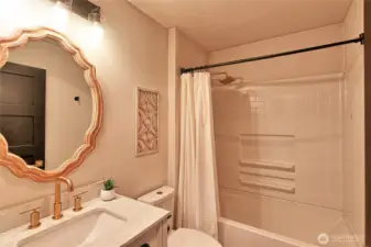 Full bath in hallway off kitchen and bedrooms.