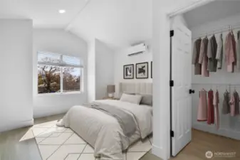 Primary bedroom with vaulted ceilings and a walk in closet.