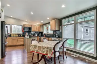 View of the dining area and kitchen from living room of main house, I love the huge windows! Handy island, beautiful cabinetry and all appliances are included.