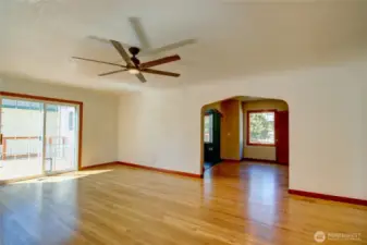 Living room with ceiling fan, slider to the sun deck and dining room entrance.