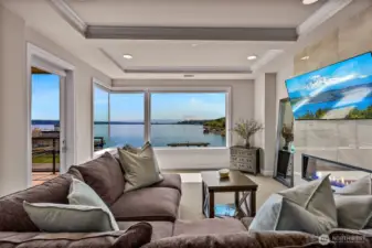 A lovely living room with colorful electric fireplace, windows galore and a door out to your very private deck.  Also, the views!