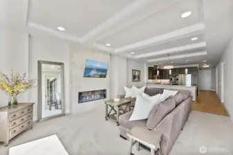 The living area offers ample room for both relaxation and entertaining, while the adjacent kitchen features modern cabinetry, stainless steel appliances, and spacious bar seating.