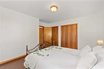 A comfortable and bright bedroom with rich wood trim and large closets, perfect for creating your own personal sanctuary.