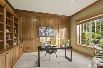Second office on the main floor with gorgeous warm-tone woodwork and built-ins.