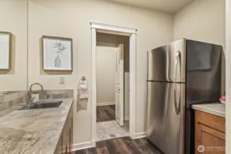 Flexible wet bar area is perfect for snacks during movie nights, or just extra storage. There's also an additional half bath and another storage room through the doors here.