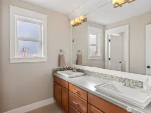 Upstairs bathroom has dual vanities, plus a separate room to shower or use the toilet.