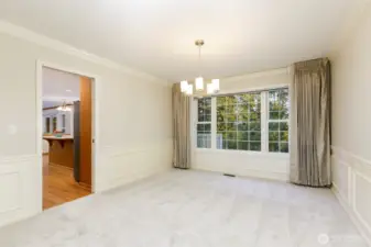 Formal dining room with all of windows overlooking the beautiful backyard trees and private lot.