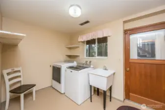 Large utility/mud room on lower level with door to back yard.  Washer & Dryer and new utility tub stay.