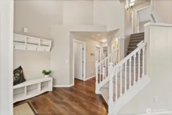 The welcoming entry features LVP hardwood flooring and a built-in seating area with coat hooks, creating a functional and inviting first impression.