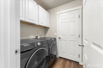 The main-level utility room offers additional storage, convenient access to the garage, and front-loading washer and dryer that will remain with the home.