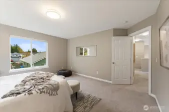 The primary bedroom is spacious and serene, featuring plush carpet that adds warmth and comfort.