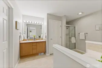 The five-piece primary bath offers a spa-like experience with dual vanities that provide ample space for daily routines.