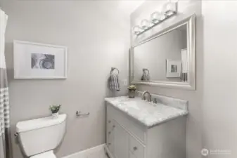 The updated upstairs full bath features a marble vanity and modern finishes, offering both style and functionality for the additional bedrooms.