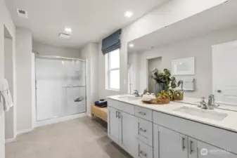 Beautiful primary bathroom 1 with double vanity and step-in shower. Actual home is under construction. Colors, materials, and features may vary. See site agent for details.