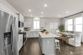 Modern kitchen with shaker style cabinets with soft close doors, quartz countertops, and stainless-steel appliances. Actual home is under construction. Colors, materials, and features may vary. See site agent for details.