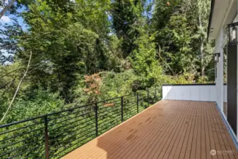 Spacious deck surrounded by lush greenery, offering a perfect retreat for outdoor relaxation.