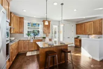 Kitchen features maple cabinets, slab granite countertops, center island and huge pantry.