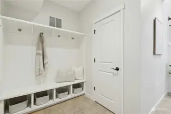 Lower level mudroom with built-ins and extra storage closet under the stairway