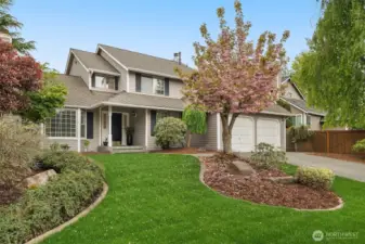 Front of home with mature landscape