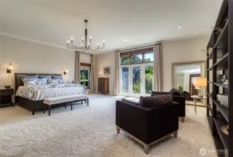 Spacious Primary bedroom suite on main level, doors leading to rear yard & hot tub. Features new paint and updated light fixtures.