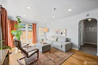 Living space with abundant natural light and curved hallway entrance.